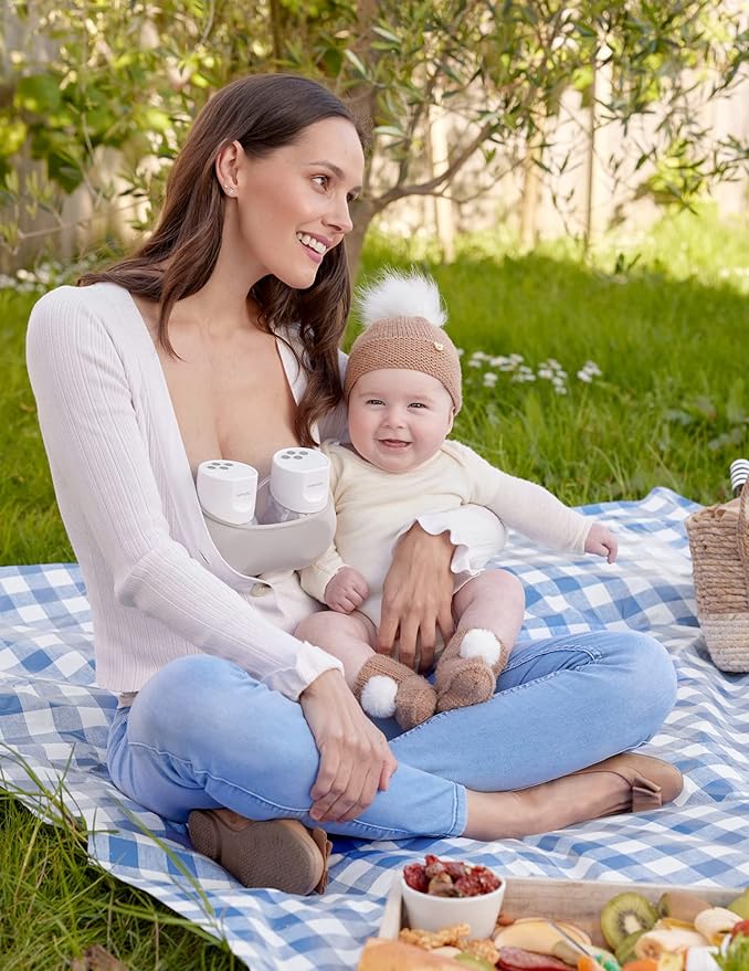 Mom using portable breast pump while doing picnic with her baby