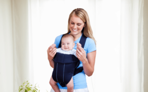 Happy mom wearing her baby in a baby carrier