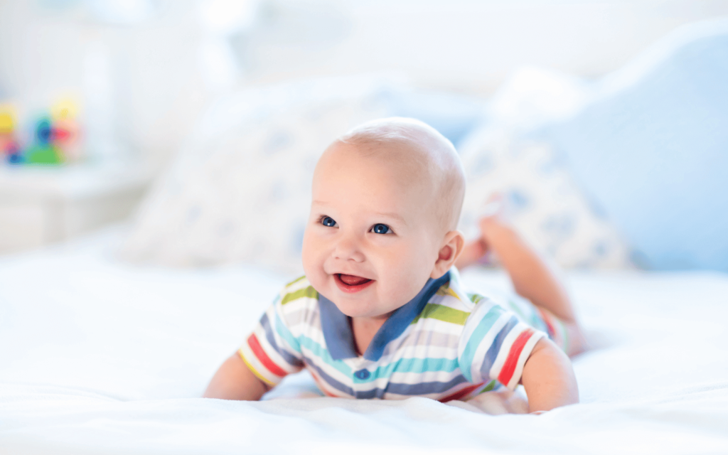 a smiling baby doing tummy time