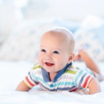 a smiling baby doing tummy time