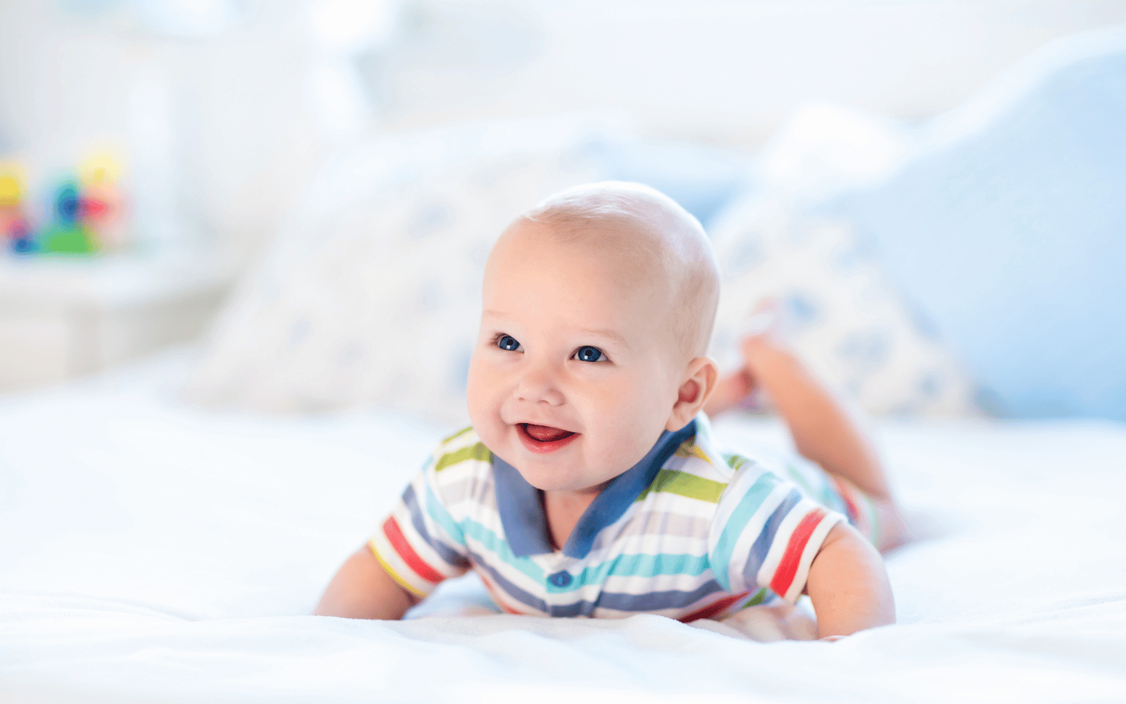 a smiling baby doing tummy time