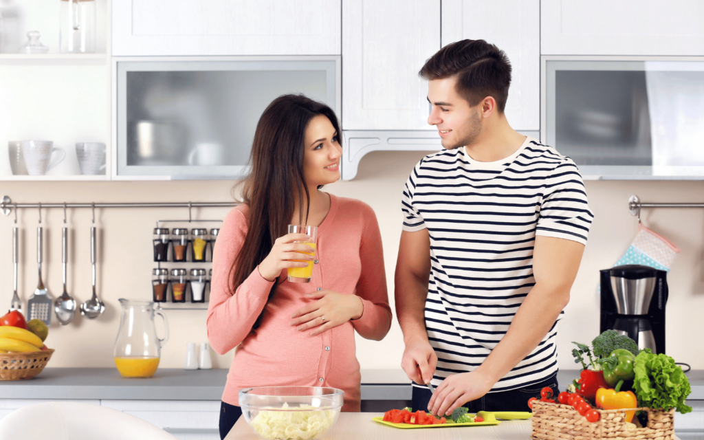 Husband making a salad to his pregnant wife