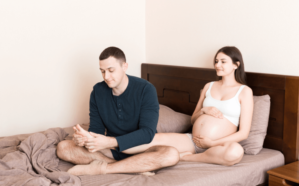 Husband giving a foot massage to his pregnant wife 