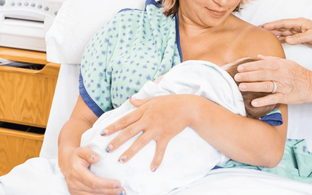 mom breastfeeding her baby in the delivery room after birth