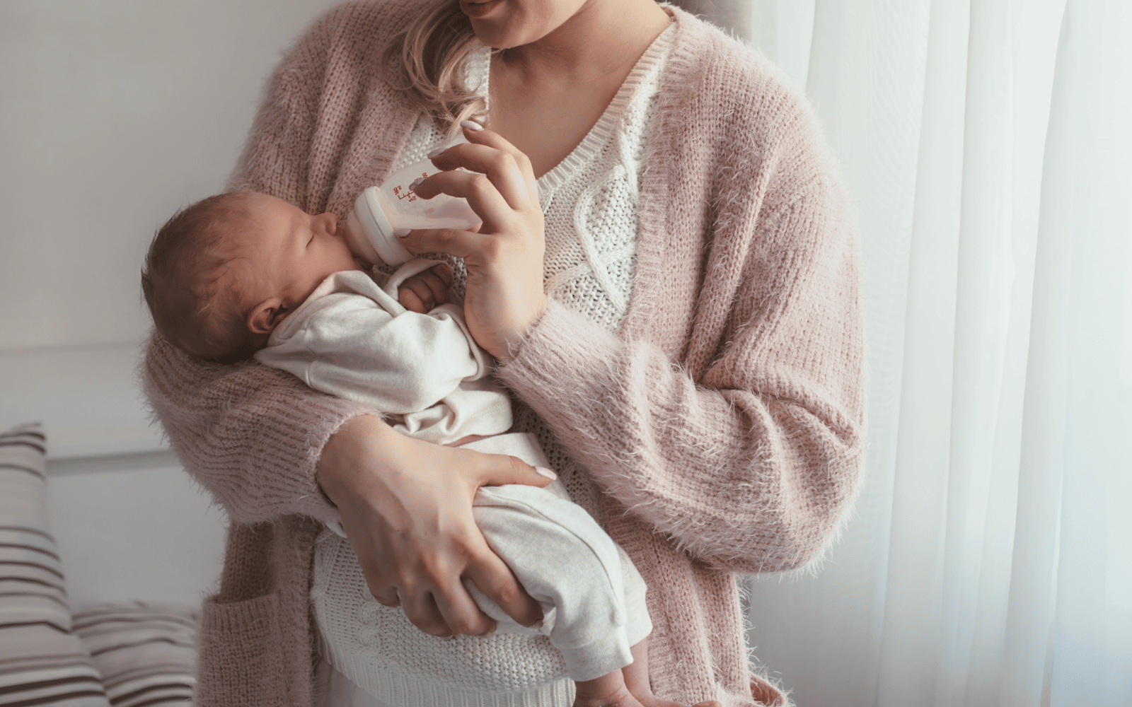 mom feeding her baby formula with a bottle