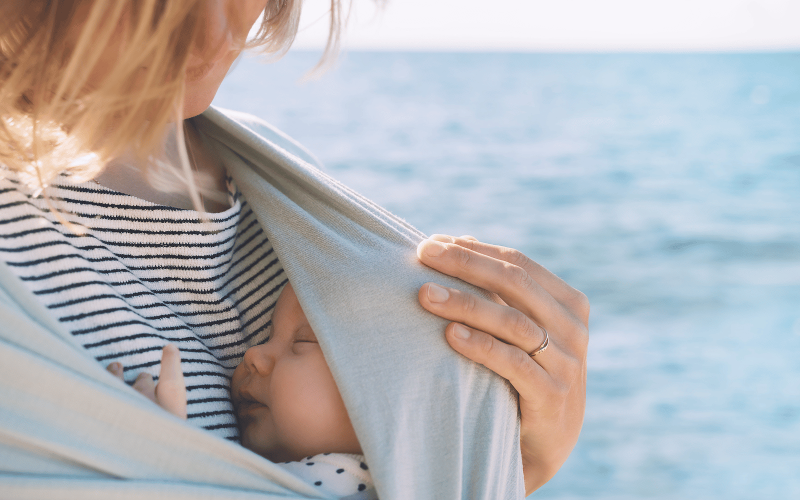 mom is wearing her baby in a wrap carrier